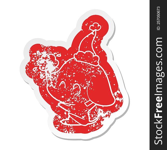 cute quirky cartoon distressed sticker of a elephant spouting water wearing santa hat