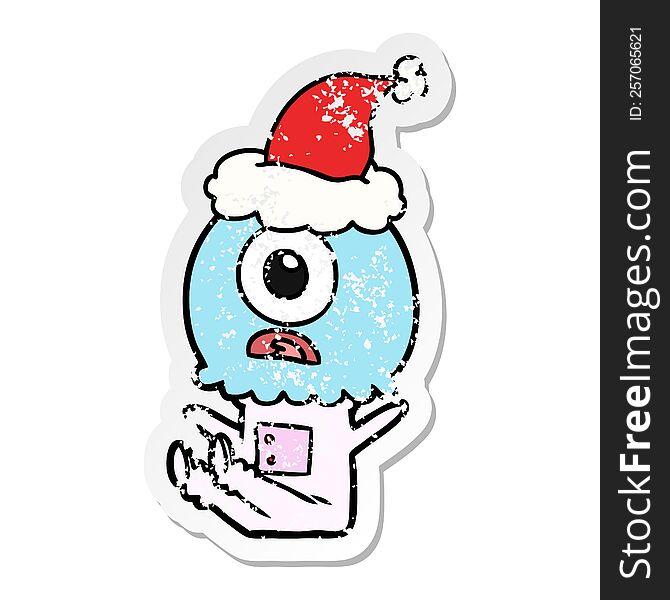 hand drawn distressed sticker cartoon of a cyclops alien spaceman wearing santa hat