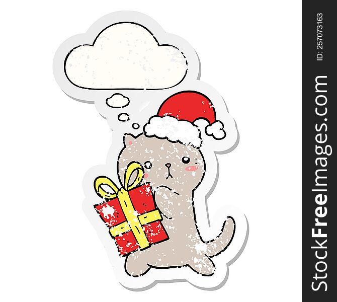 cute cartoon cat carrying christmas present with thought bubble as a distressed worn sticker