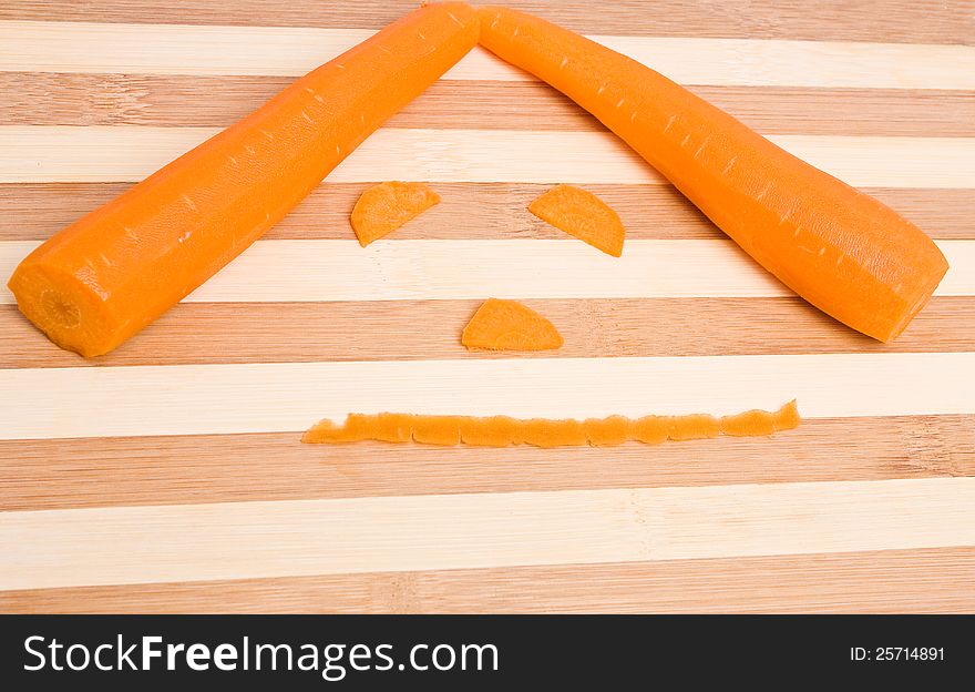 Fresh orange carrots as a face on the kitchen board. Fresh orange carrots as a face on the kitchen board.