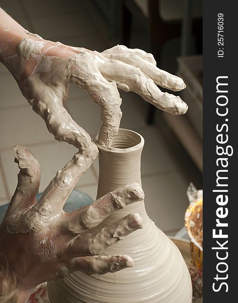 Hands of a potter, creating an earthen jar on the circle