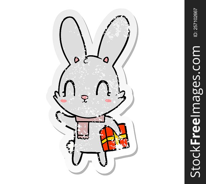 Distressed Sticker Of A Cute Cartoon Rabbit With Christmas Present