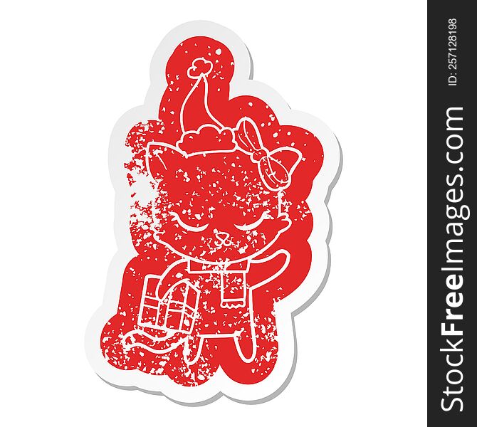 cute cartoon distressed sticker of a cat with present wearing santa hat