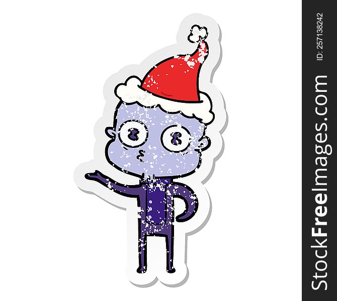 distressed sticker cartoon of a weird bald spaceman wearing santa hat