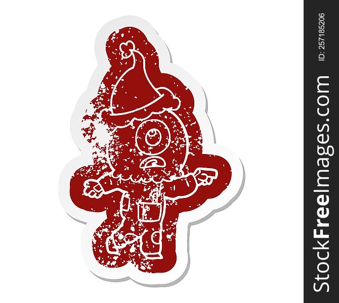 Cartoon Distressed Sticker Of A Cyclops Alien Spaceman Pointing Wearing Santa Hat