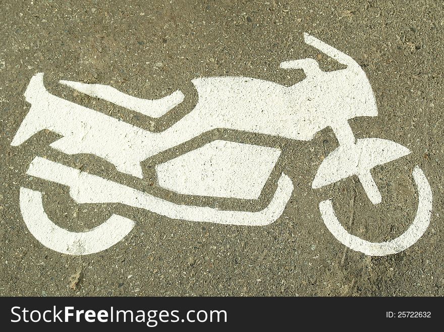 White painted motorcycle icon on a concrete surface. White painted motorcycle icon on a concrete surface.