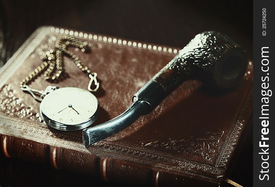 Abstract retro still life with old leather covered book and watch