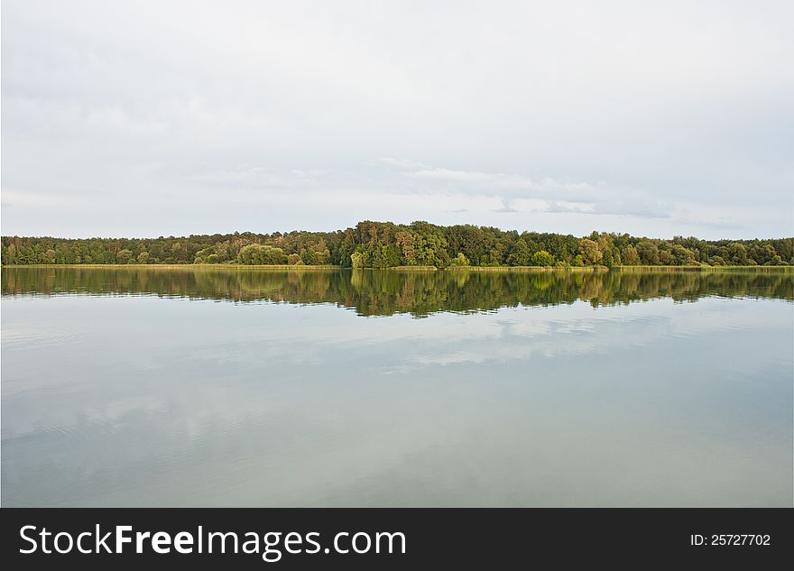 Sky and green trees in nature over lake with reflections. Sky and green trees in nature over lake with reflections