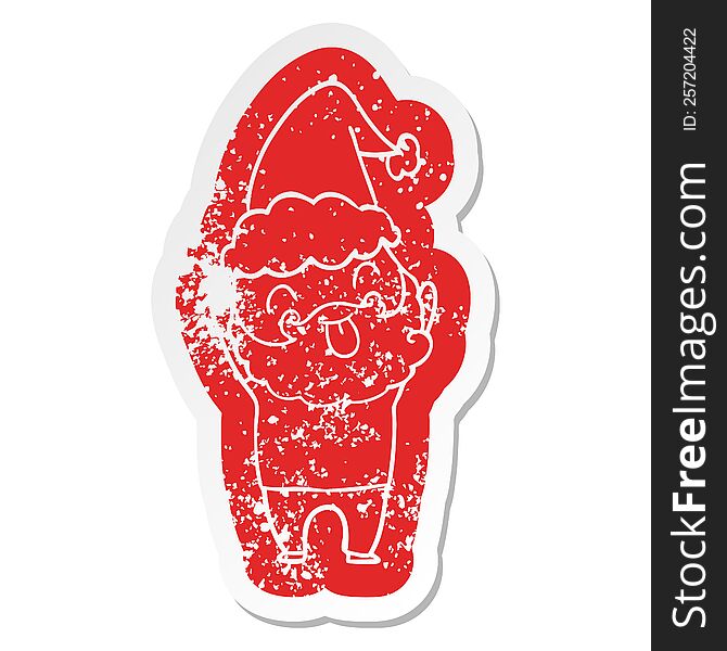 Distressed Sticker Featuring Man With Beard Sticking Out Tongue Wearing Santa Hat