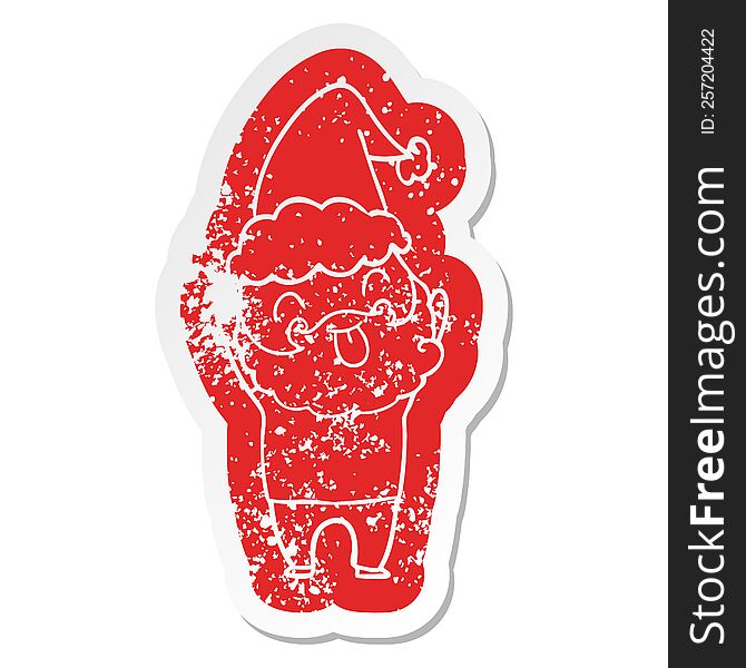 Distressed sticker featuring man with beard sticking out tongue wearing santa hat