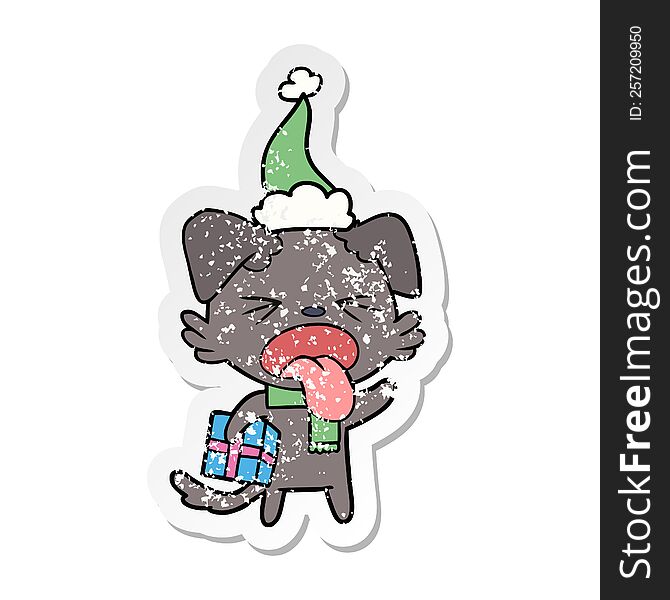 hand drawn distressed sticker cartoon of a disgusted dog with christmas gift wearing santa hat