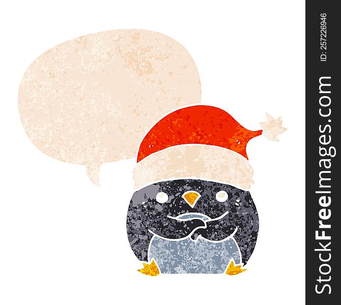 cute cartoon penguin wearing christmas hat and speech bubble in retro textured style