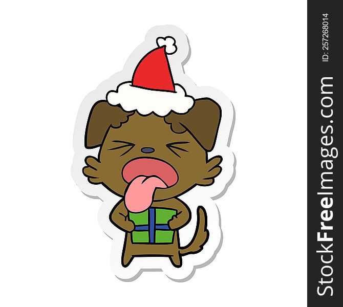 Sticker Cartoon Of A Dog With Christmas Present Wearing Santa Hat