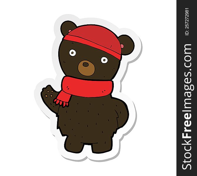 sticker of a cartoon black bear in winter hat and scarf