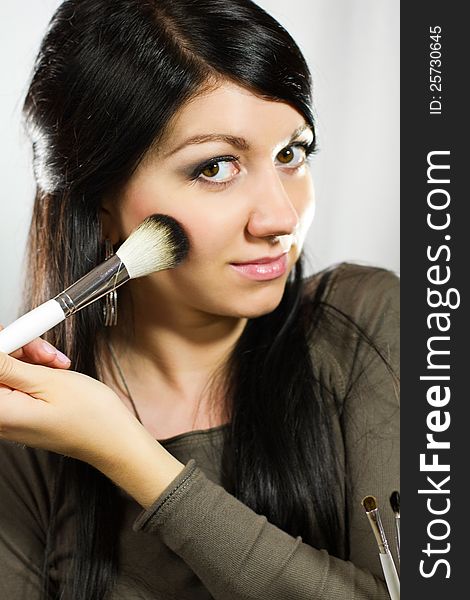 Portrait of beautiful young adult woman applying cosmetic. Portrait of beautiful young adult woman applying cosmetic