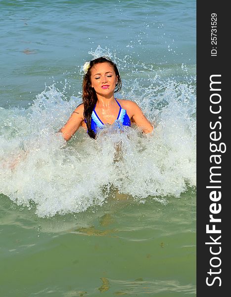 Image of a girl standing in the wave splashing water around her