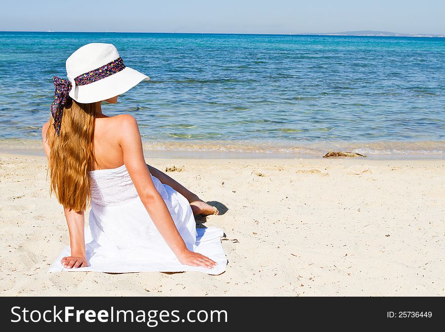 Young Woman Sitting On The Beach