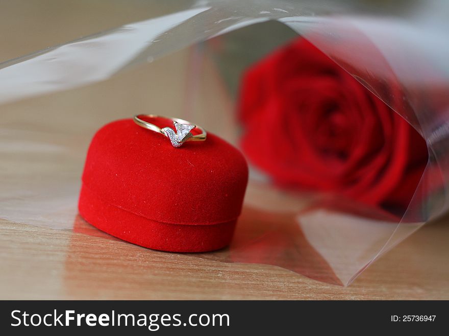 Diamond ring on the red box and red roses in the background