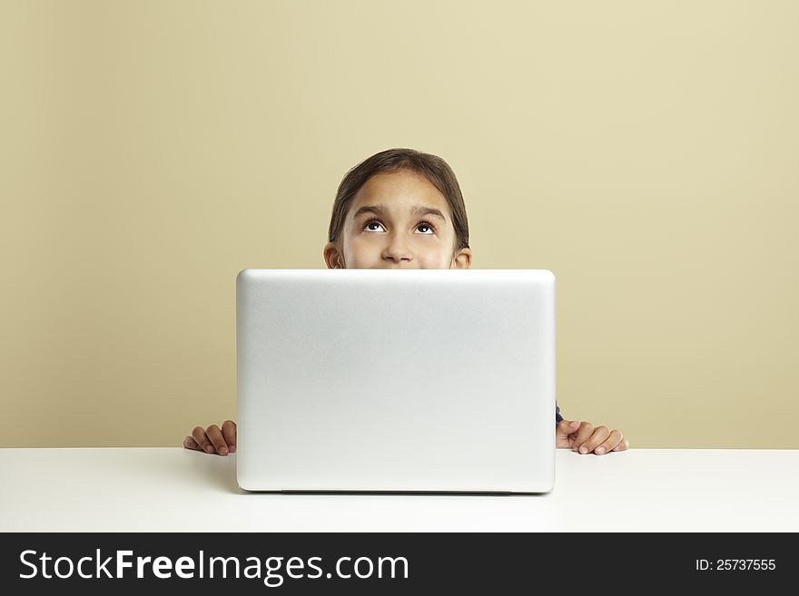 Young girl using laptop on white desk