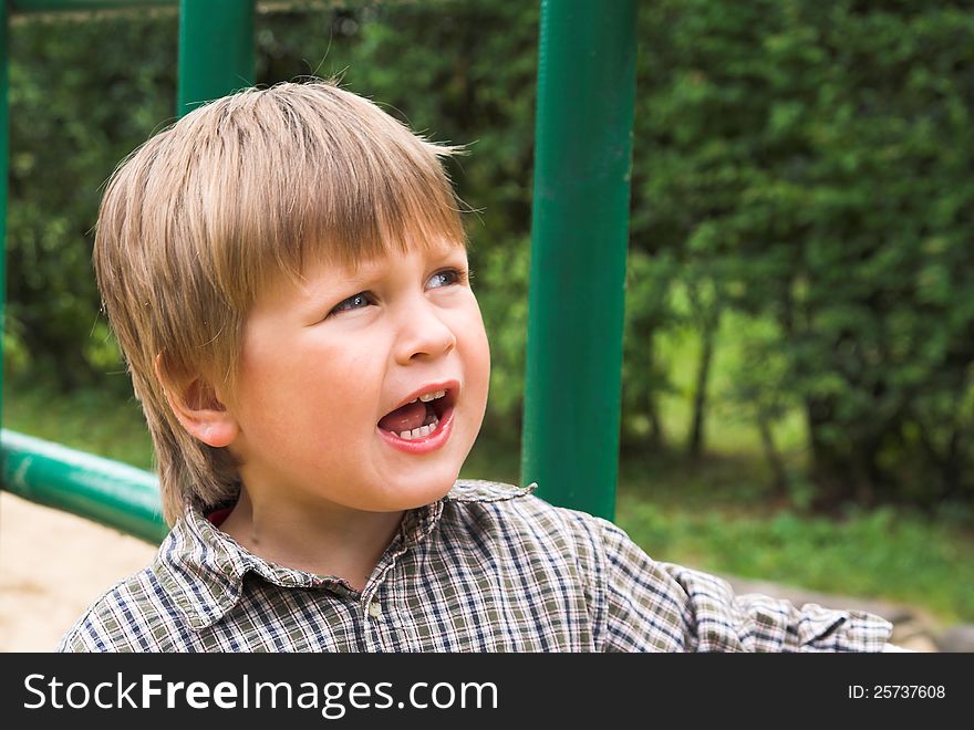 Little boy plays on the playground, shouting and singing. Little boy plays on the playground, shouting and singing