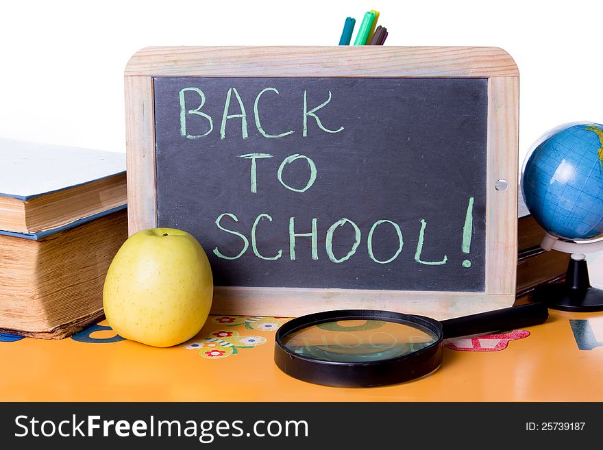 Back to school word on board, books and globe on student table