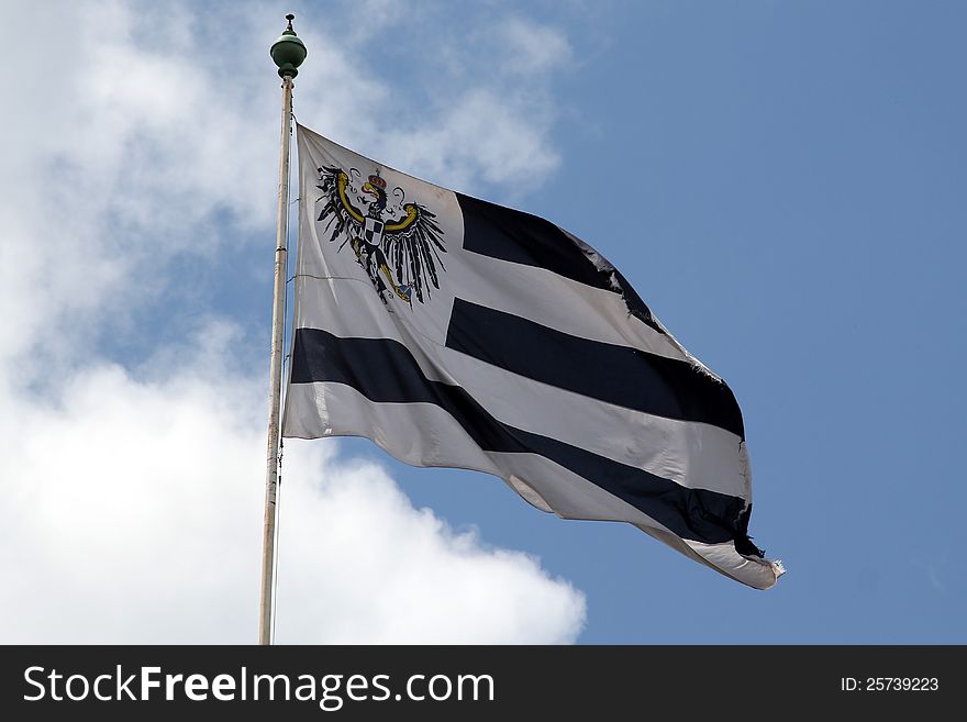 Flag of the German royal family of Hohenzollern flying in the wind with cloudy background. Flag of the German royal family of Hohenzollern flying in the wind with cloudy background.
