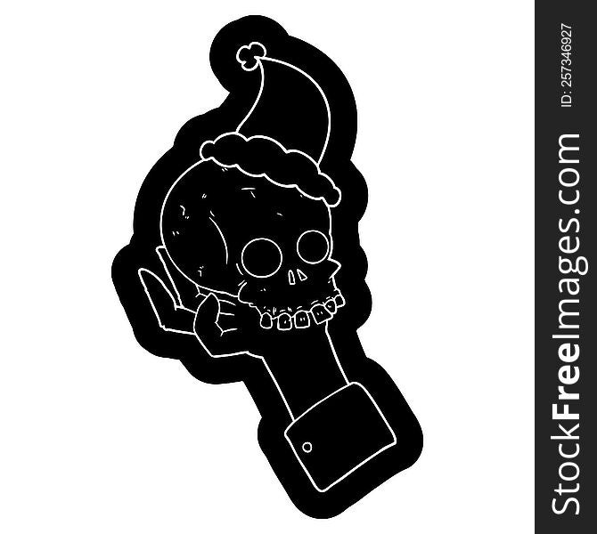 Cartoon Icon Of A Hand Holding Skull Wearing Santa Hat