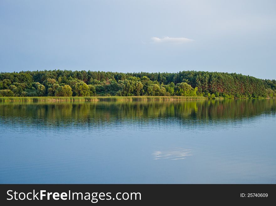 The river with white clouds reflecting in its waters.