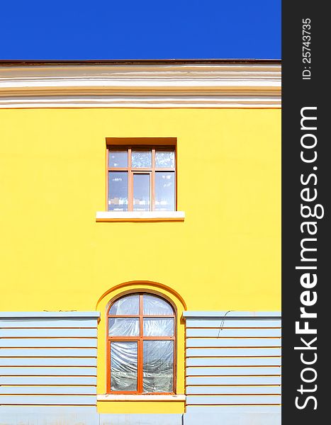 Yellow wall with windows and blue sky. Yellow wall with windows and blue sky