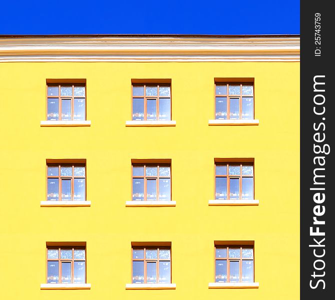 Yellow wall with windows and blue sky