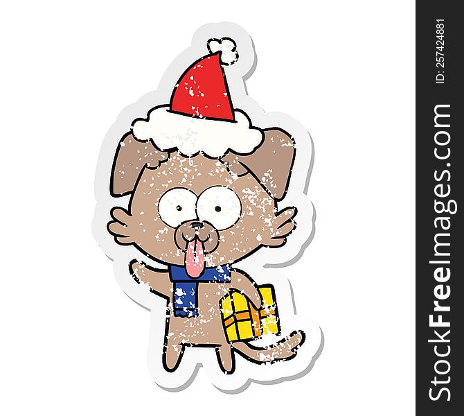 hand drawn distressed sticker cartoon of a dog with christmas present wearing santa hat