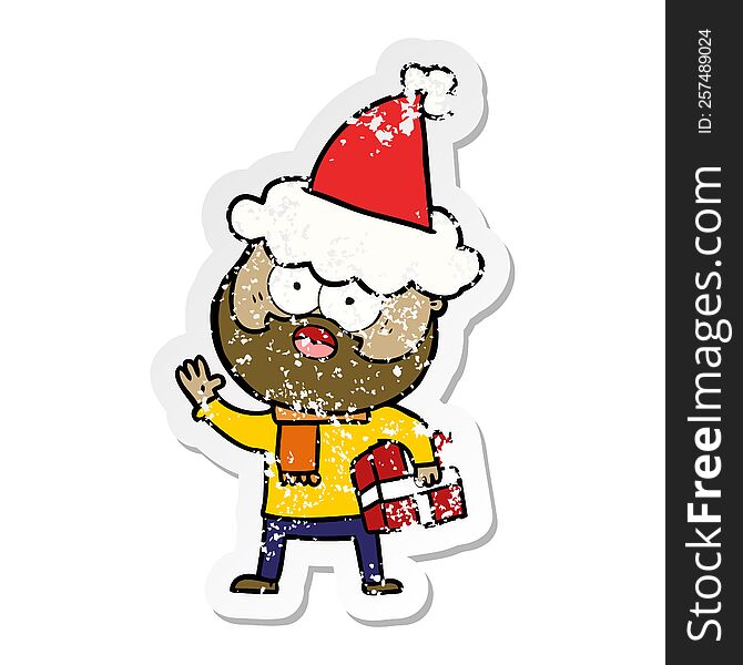 hand drawn distressed sticker cartoon of a bearded man with present wearing santa hat