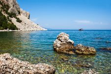 The Yacht Sails From The Rocky Sea Coast Royalty Free Stock Image The Yacht Sails From The Rocky Sea Coast Royalty Free Stock Image