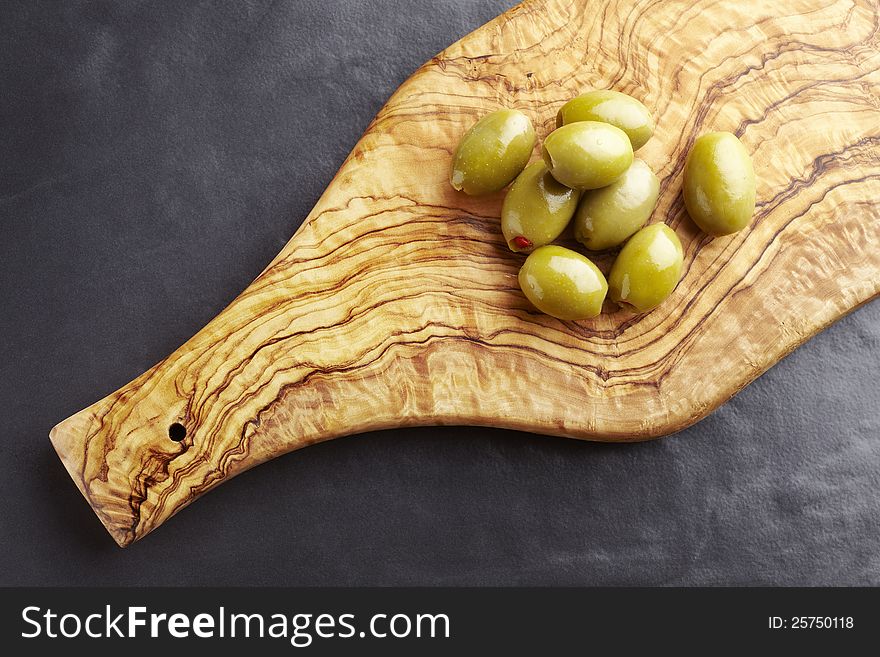Green olives on olive wood platter
