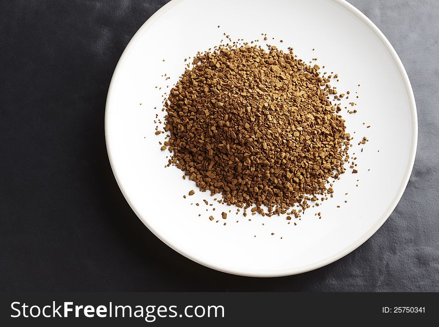 Instant coffee granules on white plate