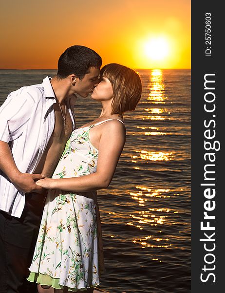 Young couple kissing at sunset on the sea. Young couple kissing at sunset on the sea