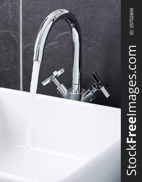 Sink tap in grey tiled contemporary bathroom. Sink tap in grey tiled contemporary bathroom