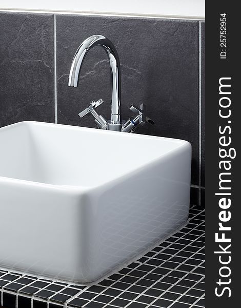 Sink tap in grey tiled contemporary bathroom. Sink tap in grey tiled contemporary bathroom