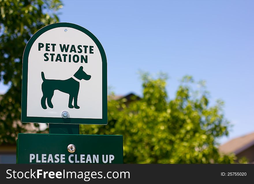 A pet waste station sign in a community park.