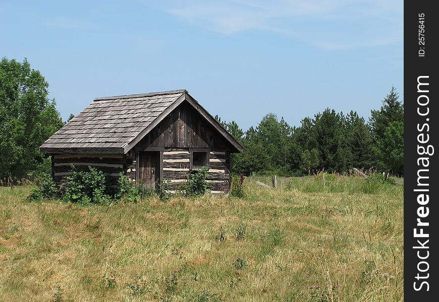 Old log shack in a field.