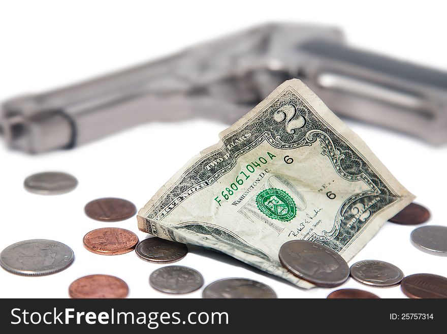 Crumpled banknote and coins on a white background and a gun. Crumpled banknote and coins on a white background and a gun