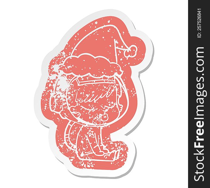 quirky cartoon distressed sticker of a pretty astronaut girl sitting waiting wearing santa hat