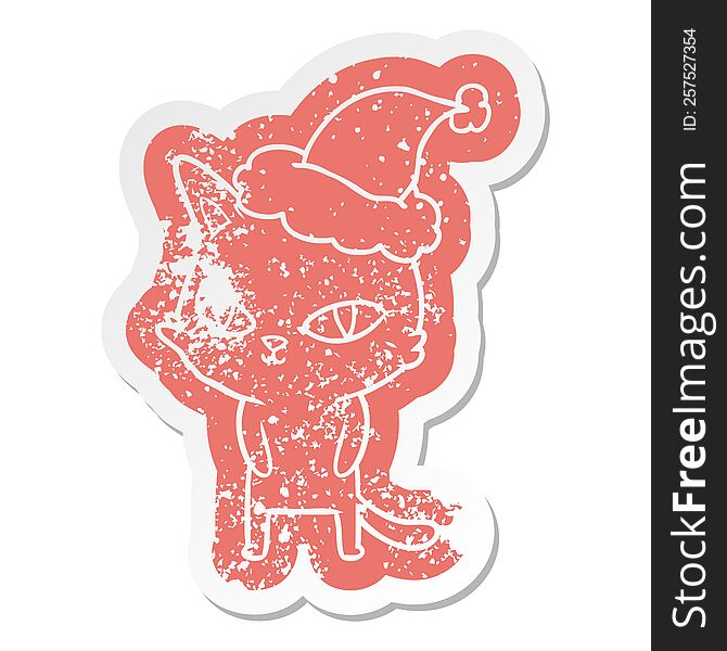 quirky cartoon distressed sticker of a cat with bright eyes wearing santa hat