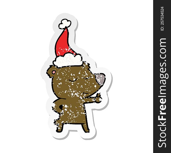 happy hand drawn distressed sticker cartoon of a bear giving thumbs up wearing santa hat
