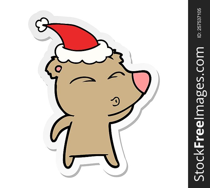 Sticker Cartoon Of A Whistling Bear Wearing Santa Hat