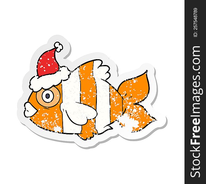 distressed sticker cartoon of a exotic fish wearing santa hat