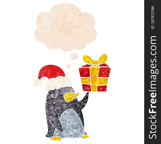 cartoon penguin with christmas present with thought bubble in grunge distressed retro textured style. cartoon penguin with christmas present with thought bubble in grunge distressed retro textured style