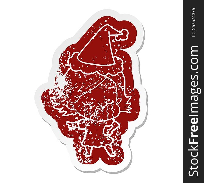 Cartoon Distressed Sticker Of A Girl Crying And Pointing Wearing Santa Hat
