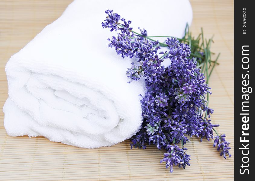 Lavender bunch with  white towel on a bamboo rug. Lavender bunch with  white towel on a bamboo rug
