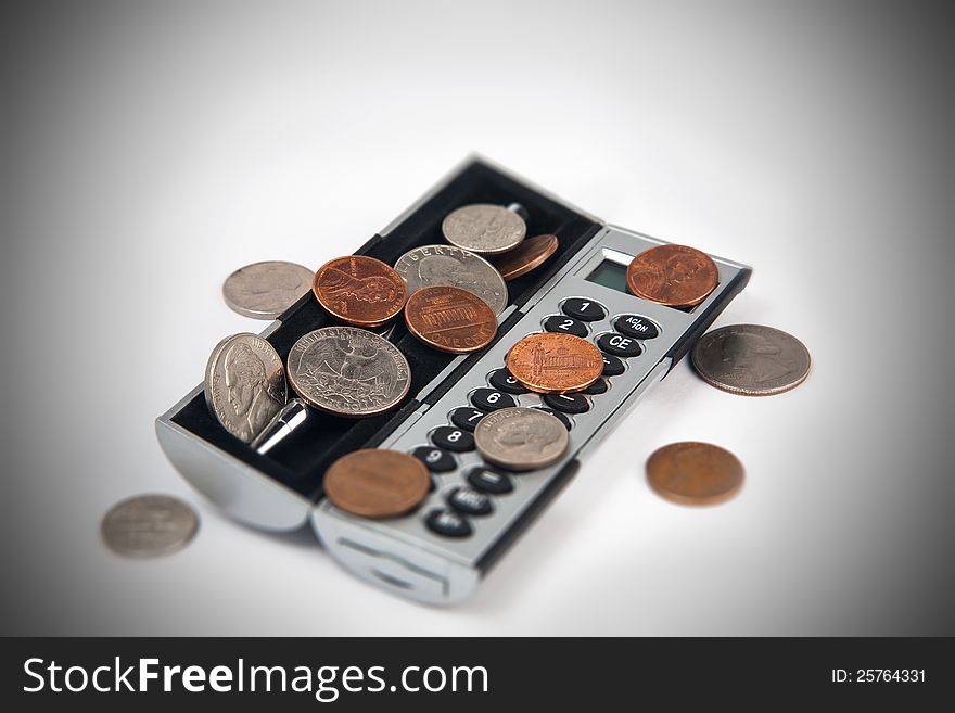 Calculator and coins on a light background